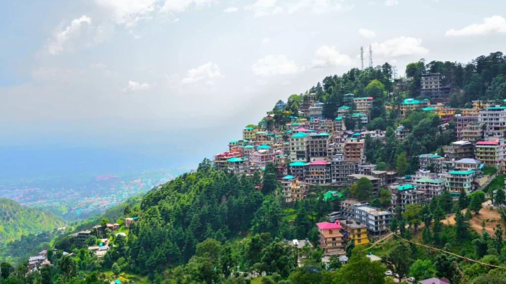 Dharamshala town nestled below the Dhauladhar mountains — best places to visit in summer in India for peaceful hill escapes and Tibetan culture.