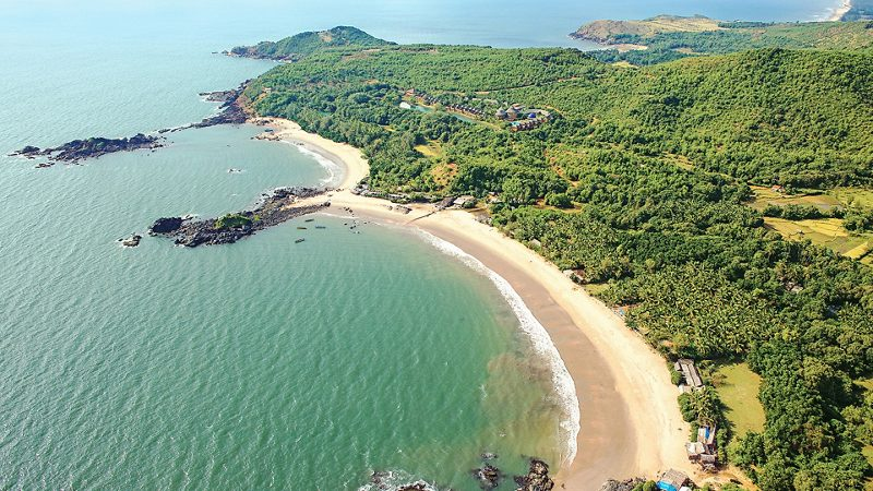 Solo traveler walking along Om Beach at sunset in Gokarna — a peaceful beach town and one of the best places in India to travel solo.