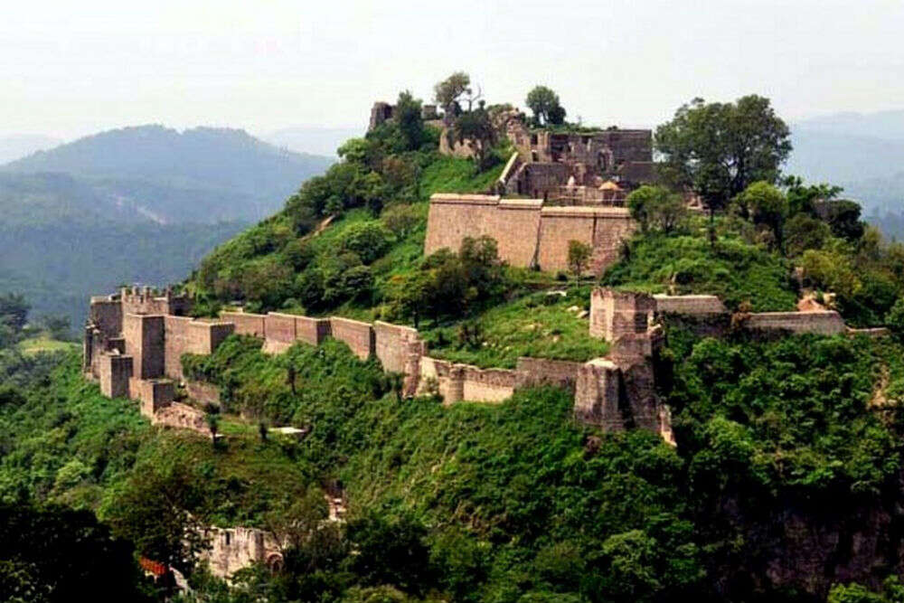 Ancient stone walls of Kangra Fort overlooking green valleys — best places to visit in summer in India for history and scenic views.