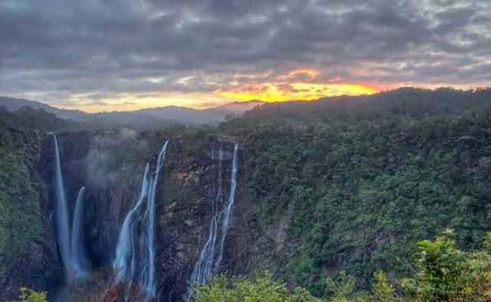 Satdhara Falls flowing through rocks and pine trees in Dalhousie — best places to visit in summer in India for peace and natural beauty.