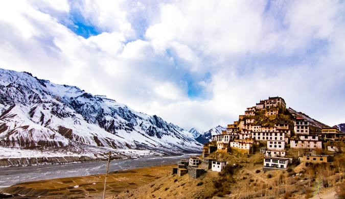 Barren mountains and a solo traveler trekking through Spiti Valley — a high-altitude desert and one of the best places in India to travel solo.
