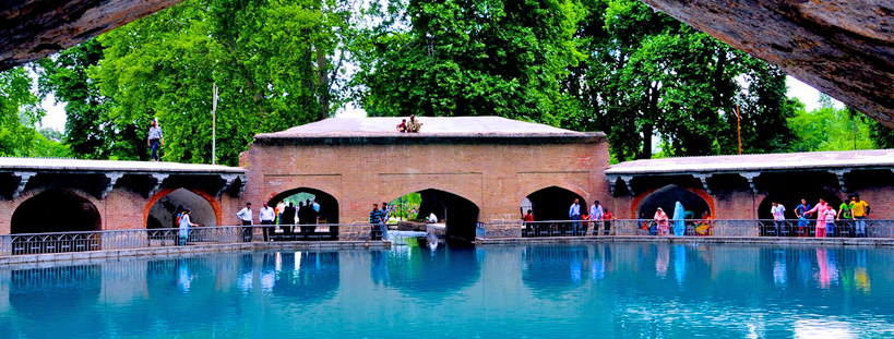Verinag (places to visit in Kashmir), featuring the iconic octagonal Mughal spring pavilion surrounded by lush gardens and crystal-clear waters.