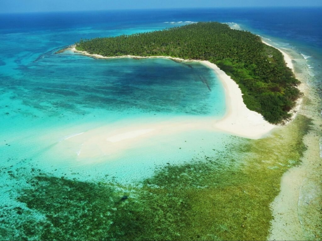 This image Tells This island around blue sea water is one of the best places to visit in india 2025