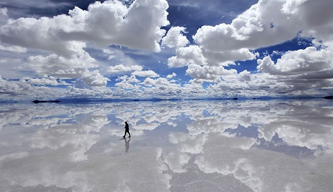 A person walking on the mirror-like surface of Salar de Uyuni — Bolivia: one of the cheap places to travel internationally.
